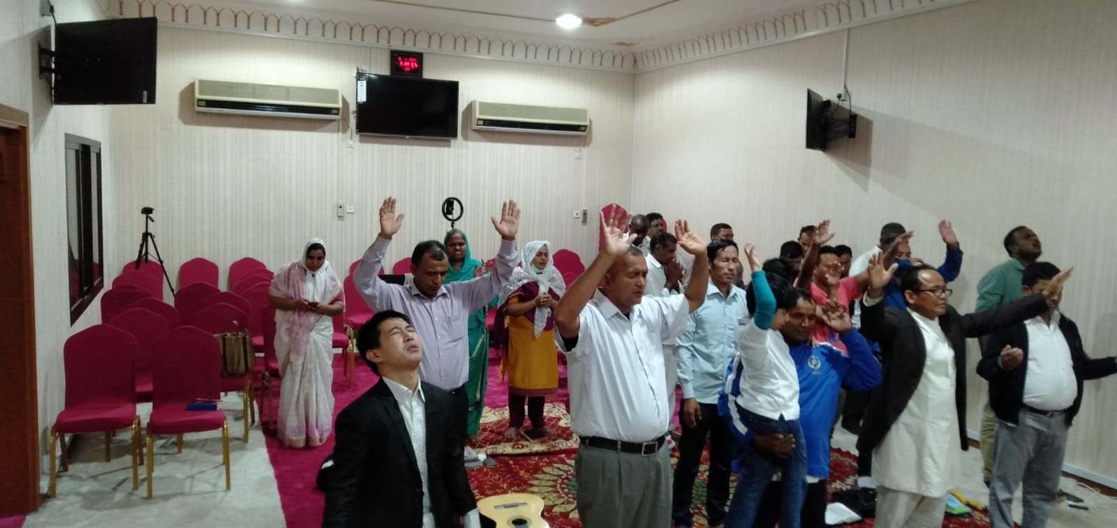 El-Shaddai Ministries community in worship with hands raised